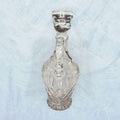 Estas Vinajeras destacan por su cuerpo de cristal transparente, con forma abombada, cuello estrecho, pico vertedor curvado y asa lateral.