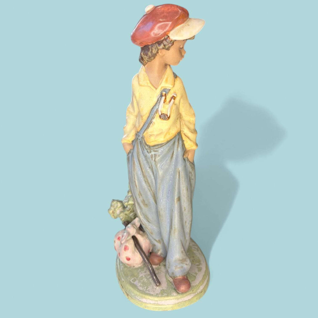 La figura “Niño Viajero” (Wanderer Boy) de Lladró representa a un joven caminante apoyado en un hito de carretera marcado con la inscripción “N-330”, evocando el espíritu aventurero, la nostalgia de los viajes y la sencillez de la vida rural.

