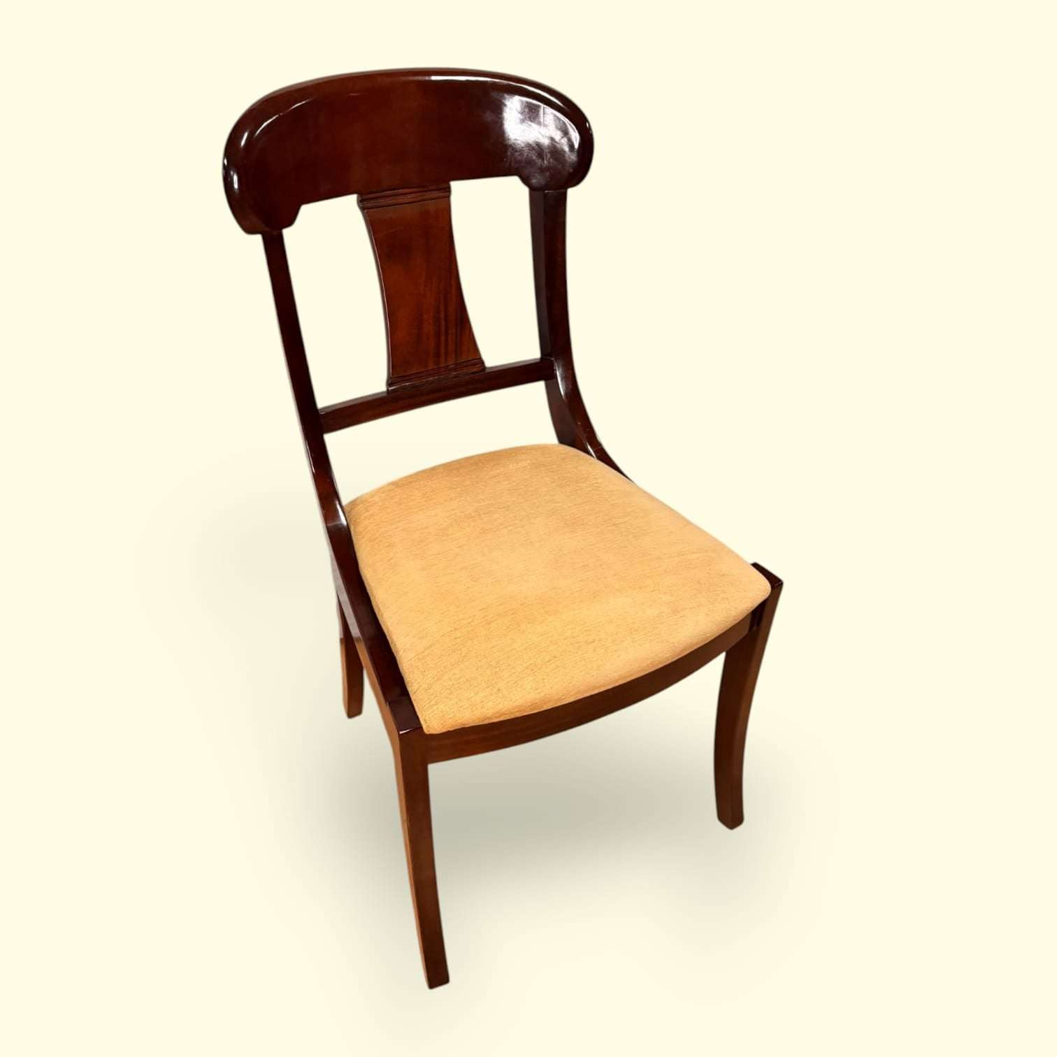 Originalmente diseñada para acompañar mesas de comedor y espacios de reunión, hoy esta pieza mantiene toda su funcionalidad y añade un fuerte valor decorativo gracias a la calidad visual de la caoba y la suavidad de su asiento tapiza