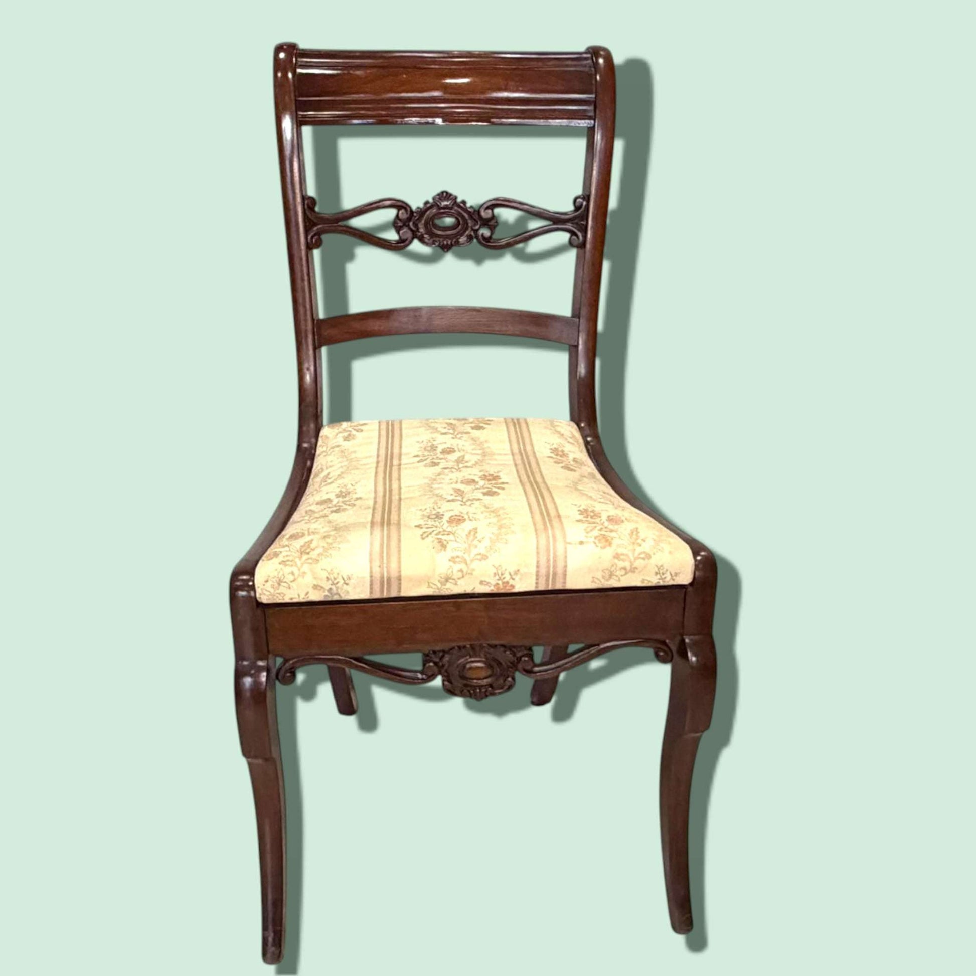 Estas piezas destacan por la belleza de su madera noble, sus líneas refinadas y los delicados detalles ornamentales presentes tanto en el respaldo como en el faldón frontal.