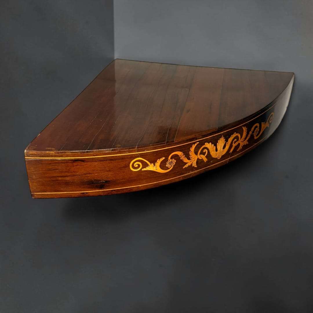 La delicada taracea frontal aporta un atractivo ornamental que realza la nobleza de la madera y refleja el gusto por la ebanistería clásica. 