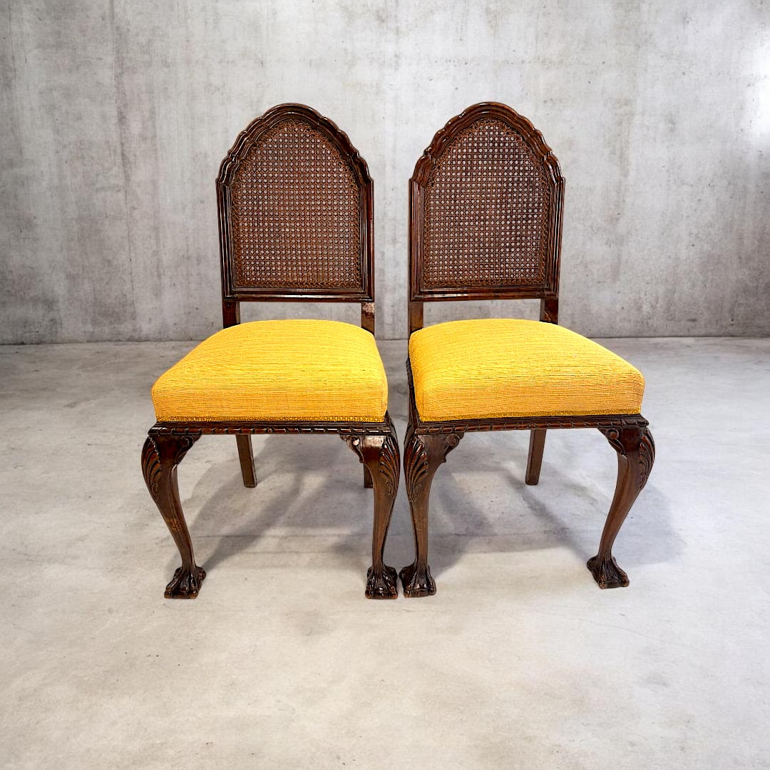 Esta refinada pareja de sillas antiguas de madera combina la elegancia clásica de la madera noble con la delicadeza artesanal de su respaldo de rejilla y sus estilizadas patas talladas.
