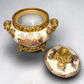 Formado por tres recipientes ornamentales con tapa, combina fondo marfil craquelado, motivos florales multicolor y relieves dorados de gran impacto visual.

Su función original es guardar joyas, pequeños recuerdos, bisutería, llaves, medallas o piezas delicadas. Hoy también destaca como objeto decorativo y de colección, ideal para vitrinas, tocadores, apar