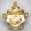 Formado por tres recipientes ornamentales con tapa, combina fondo marfil craquelado, motivos florales multicolor y relieves dorados de gran impacto visual.

Su función original es guardar joyas, pequeños recuerdos, bisutería, llaves, medallas o piezas delicadas. Hoy también destaca como objeto decorativo y de colección, ideal para vitrinas, tocadores, apar