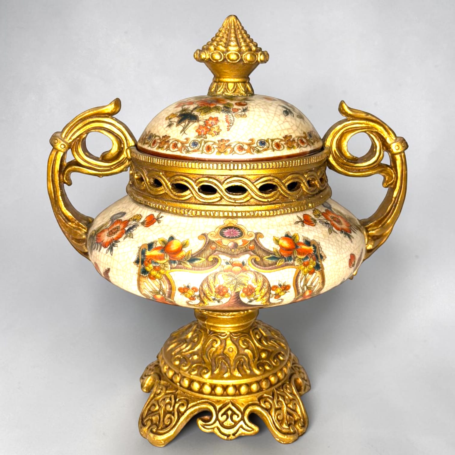 Formado por tres recipientes ornamentales con tapa, combina fondo marfil craquelado, motivos florales multicolor y relieves dorados de gran impacto visual.

Su función original es guardar joyas, pequeños recuerdos, bisutería, llaves, medallas o piezas delicadas. Hoy también destaca como objeto decorativo y de colección, ideal para vitrinas, tocadores, apar