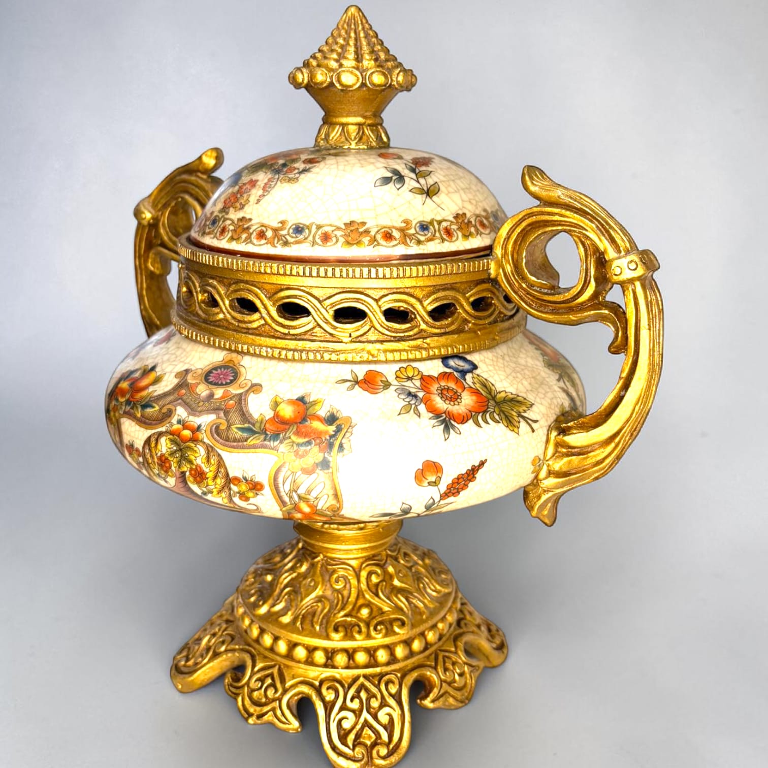 Formado por tres recipientes ornamentales con tapa, combina fondo marfil craquelado, motivos florales multicolor y relieves dorados de gran impacto visual.

Su función original es guardar joyas, pequeños recuerdos, bisutería, llaves, medallas o piezas delicadas. Hoy también destaca como objeto decorativo y de colección, ideal para vitrinas, tocadores, apar