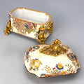 Formado por tres recipientes ornamentales con tapa, combina fondo marfil craquelado, motivos florales multicolor y relieves dorados de gran impacto visual.

Su función original es guardar joyas, pequeños recuerdos, bisutería, llaves, medallas o piezas delicadas. Hoy también destaca como objeto decorativo y de colección, ideal para vitrinas, tocadores, apar