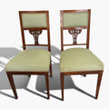 El tapizado verde tanto en el asiento como en el respaldo aporta confort visual y un atractivo contraste con la madera de tono cálido.