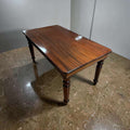 Esta Mesa presenta patas torneadas de estilo clásico, con volúmenes redondeados y anillos decorativos en tono oscuro que aportan contraste visual y refinamiento.