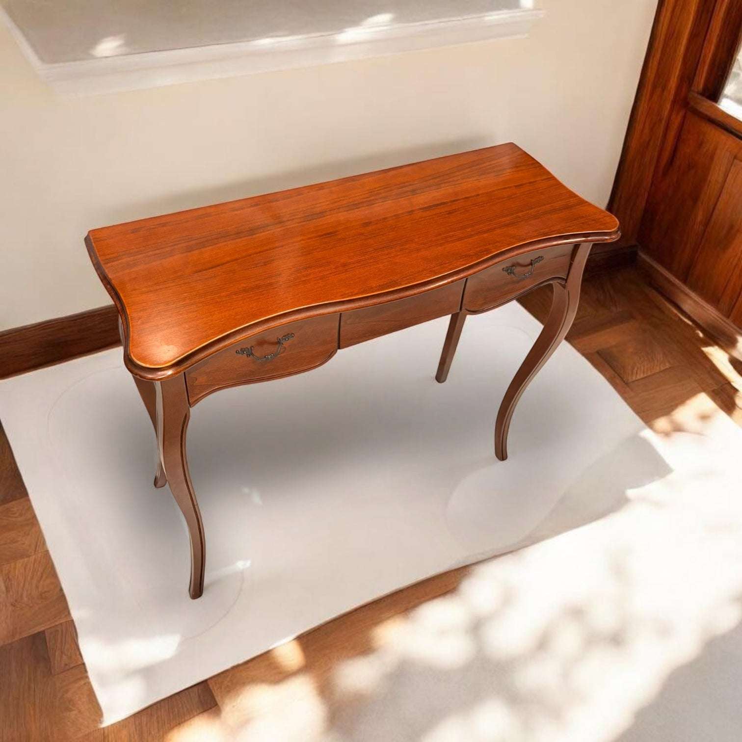 La combinación de patas curvas, cajón frontal con tirador metálico, tablero de bordes redondeados y acabado en caoba de tono cálido la diferencia de una mesa auxiliar común. Esta Consola no so