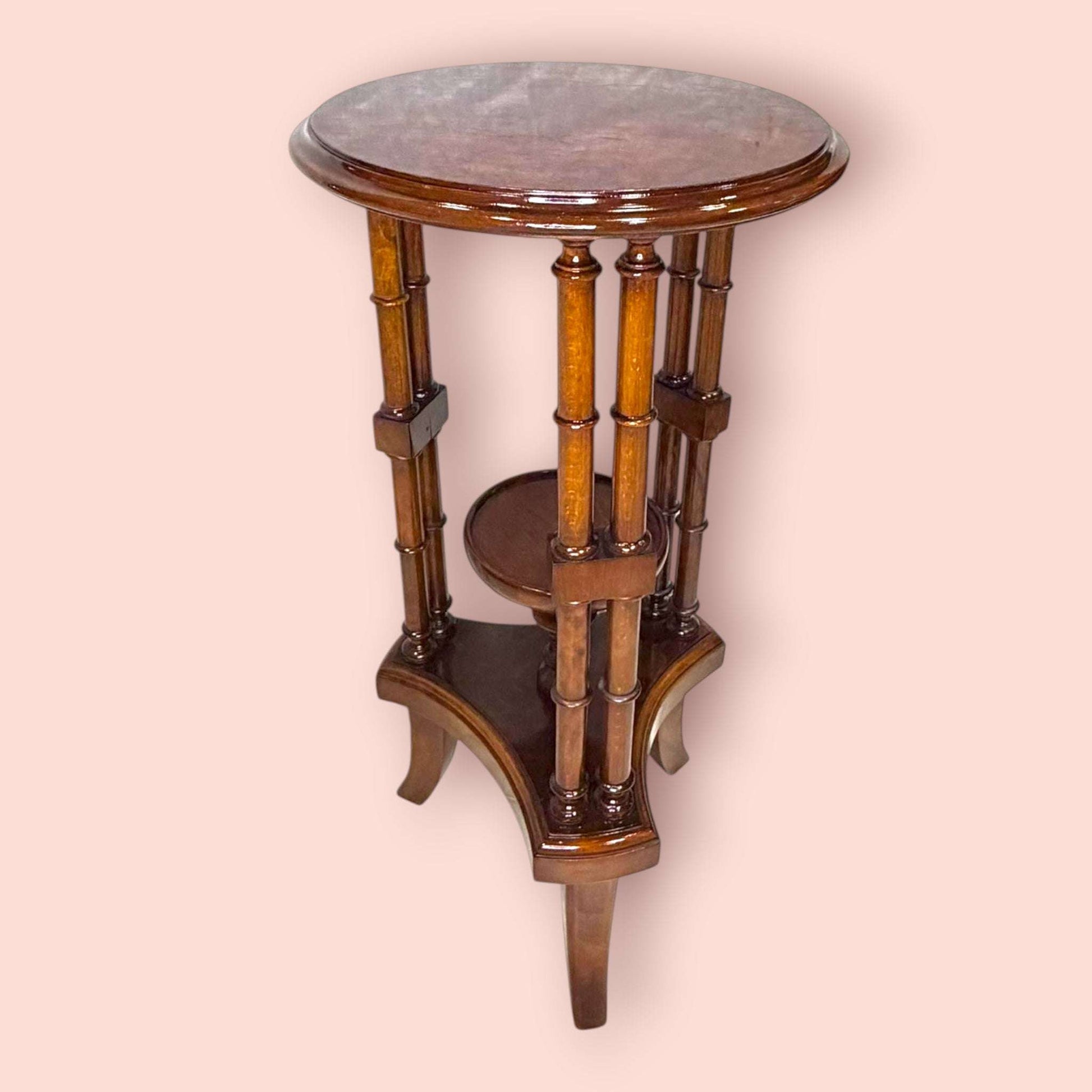 Estos Veladores destacan por una estructura muy original: tablero superior circular, columnas verticales decorativas y una pequeña repisa central que permite crear dos alturas de exposición. Esta repisa resulta perfecta para colocar una maceta con flores, una figura pequeña, una porcelana, una vela decorativa o un detalle especial, mientras que la parte superior puede utilizarse para una lámpara, un jarrón o una pieza protagonista.

En las imágenes se aprecia un acabado brillante de tono caoba cálido, con t