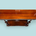 Esta Consola de caoba es una pieza auxiliar con gran valor decorativo, ideal para vestir recibidores, pasillos, salones, despachos o zonas de paso donde se busca un mueble estrecho, elegante y funcional. Su diseño alargado permite colocarla junto a una pared sin ocupar demasiado espacio, aportando calidez, orden y una estética clásica muy cuidada.

Su función original era servir como mueble de apoyo en entradas y salones, utilizado para colocar lámparas, jarrones, marcos, bandejas, llaves u objetos decorati