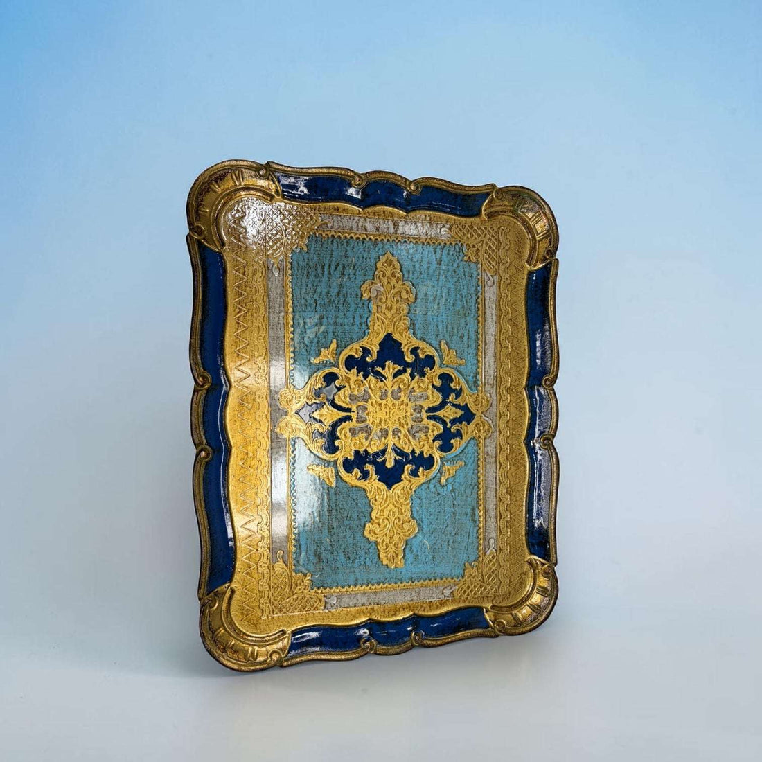  Está pintada a mano en tonos azul celeste, azul intenso y dorado, con una composición central ornamental que recuerda a los motivos clásicos de la decoración florentina. 