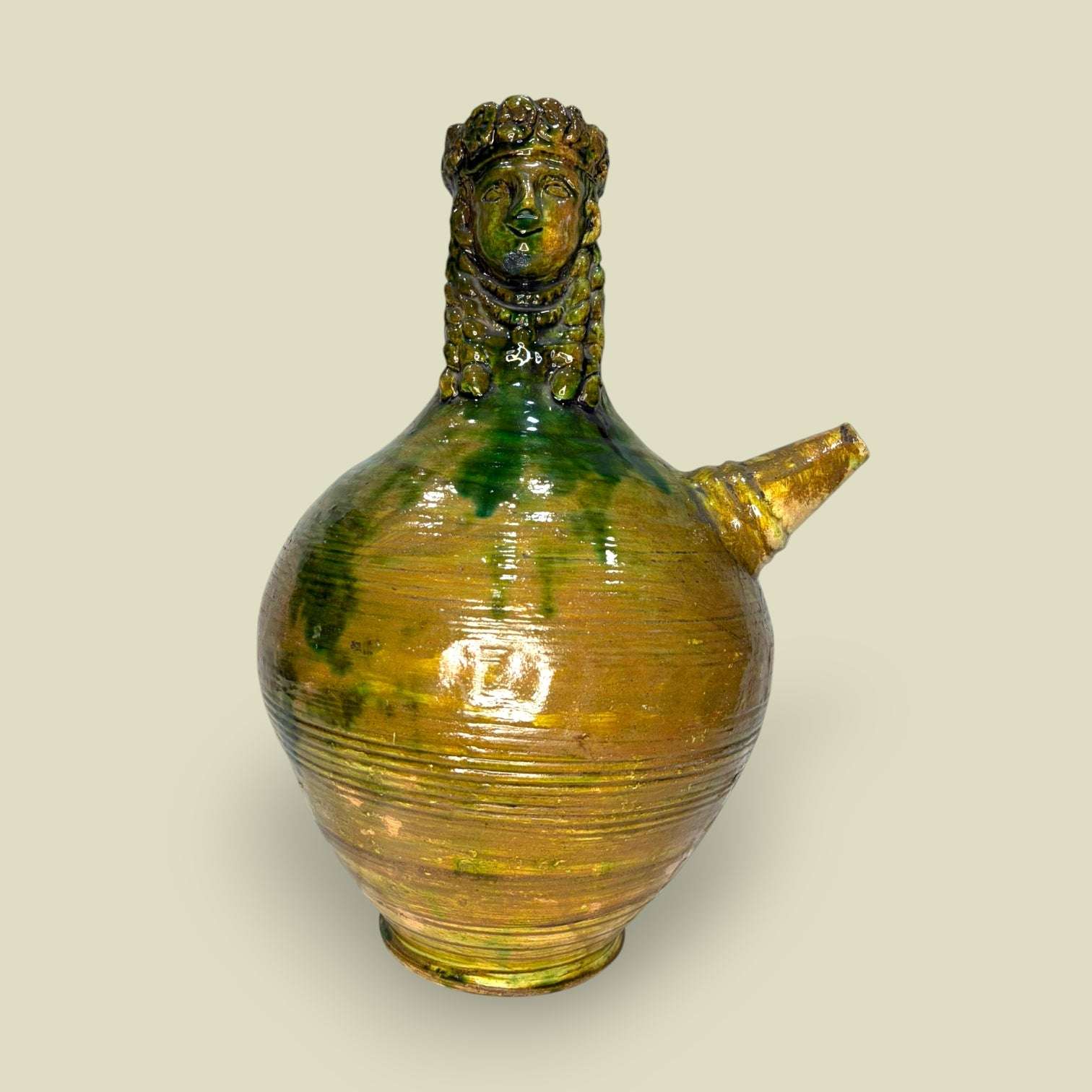 Botijo decorativo de cerámica con figura de hombre barbudo en tonos verdes y ocres