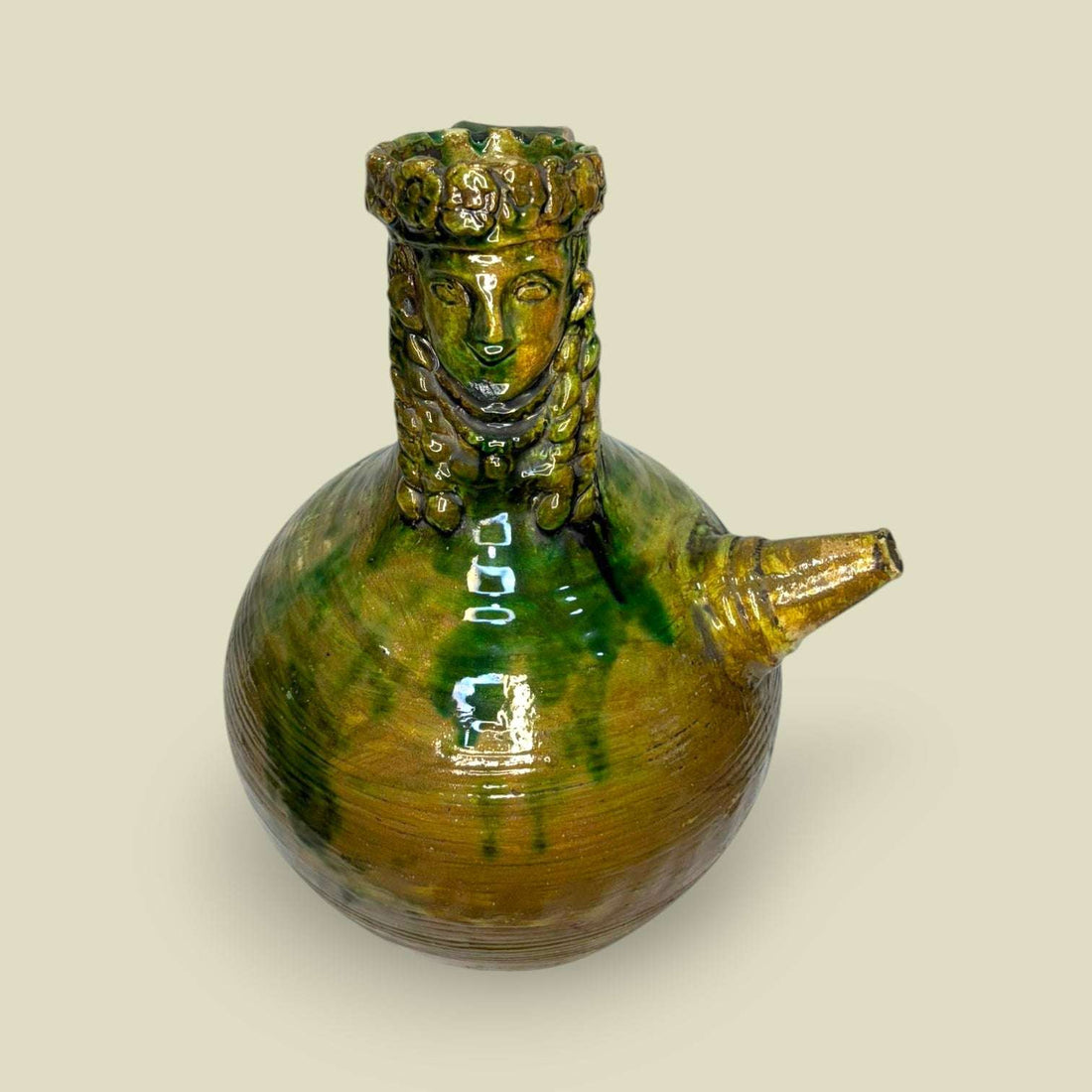 Botijo de cerámica esmaltada con figura barbuda decorativa en tonos verdes y ocres