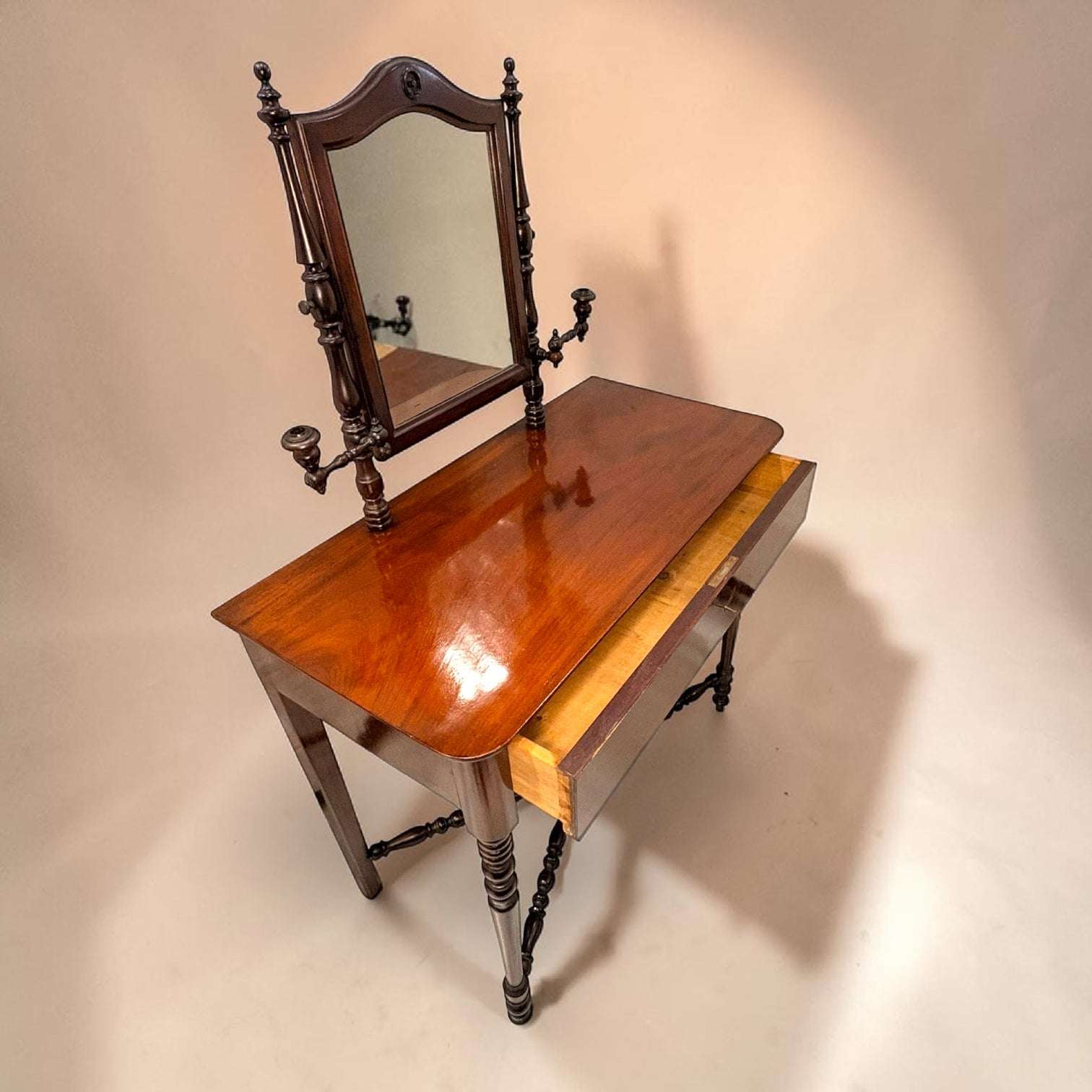 
Los soportes laterales decorativos estaban destinados originalmente a colocar velas, proporcionando iluminación frente al espejo antes de la llegada de la electricidad.

Fabricado en caoba, destaca por la belleza natural