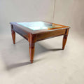 Elegante Mesa baja de salón realizada en madera de caoba, una pieza clásica y refinada que destaca por sus líneas equilibradas, su excelente presencia decorativa y su sofisticado cristal biselado central.