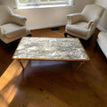 Su diseño rectangular, sus patas estilizadas y su tapa mineral con vetas naturales la convierten en una pieza perfecta para quienes buscan un mueble funcional, decorativo y con presencia.