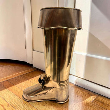 En las imágenes se aprecia un diseño muy singular con forma de bota alta, trabajado en metal plateado con acabado envejecido. 