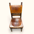 Su combinación de madera, cuero, tachuelas y talla ornamental la convierte en una pieza perfecta para decoraciones clásicas, rústicas, vintage o eclécticas.