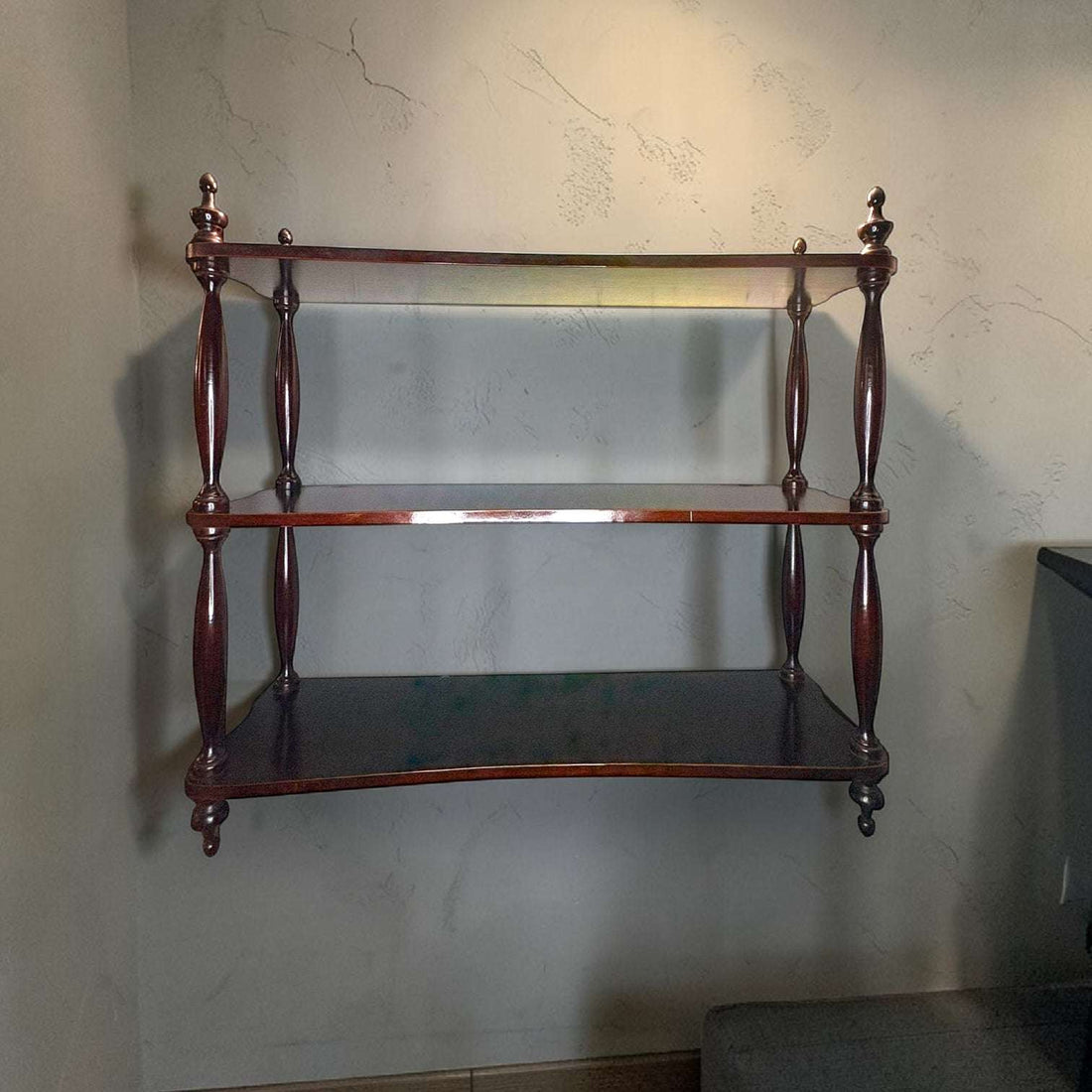 Esta Estantería destaca por su presencia visual y por el tono oscuro de la caoba, con un acabado brillante que realza la veta y aporta profundidad. 