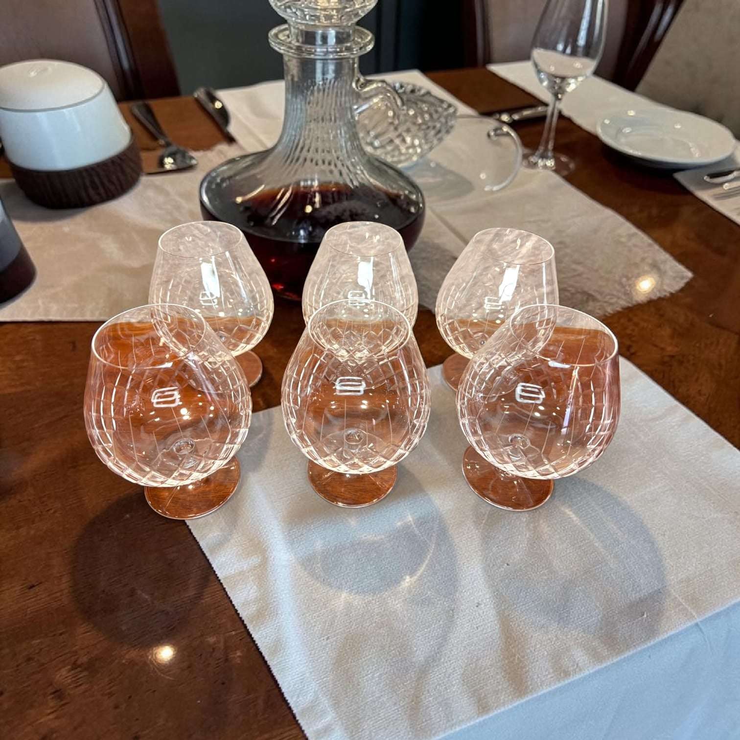 Este Juego de copas destaca por su forma redondeada, su pie bajo y estable, y su elegante trabajo de talla en el cristal.