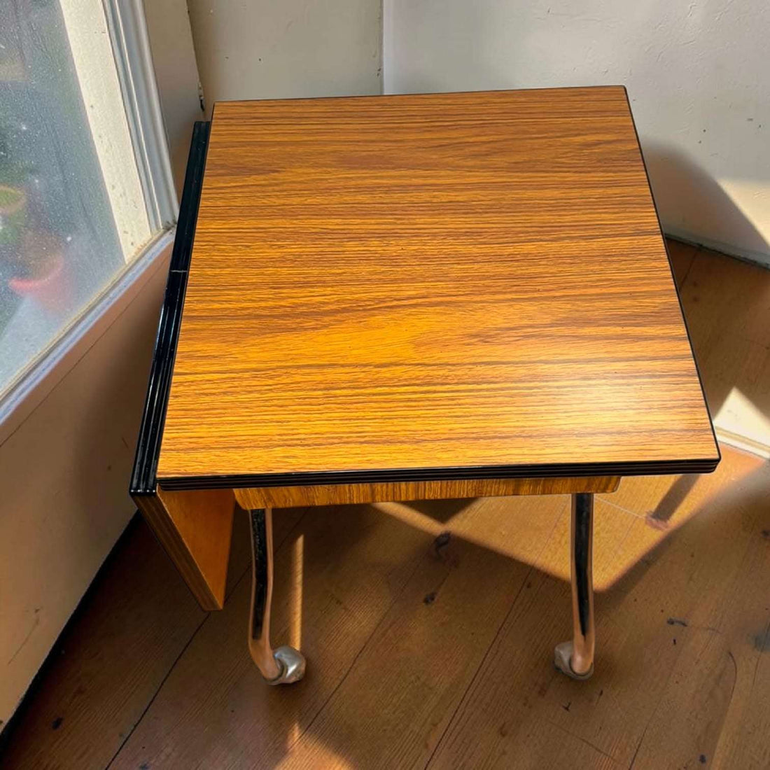 Su función original era servir como soporte auxiliar para máquina de escribir, permitiendo desplazarla con facilidad gracias a sus ruedas y ampliar la zona de trabajo mediante su lateral abatible. 
