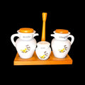 Se observan tarros de porcelana de distintos tamaños, tapas con acabado madera, dos estructuras de madera, una para presentación de mesa y otra en formato expositor, además de piezas auxiliares como plato, cuenco y recipiente de servicio. 
