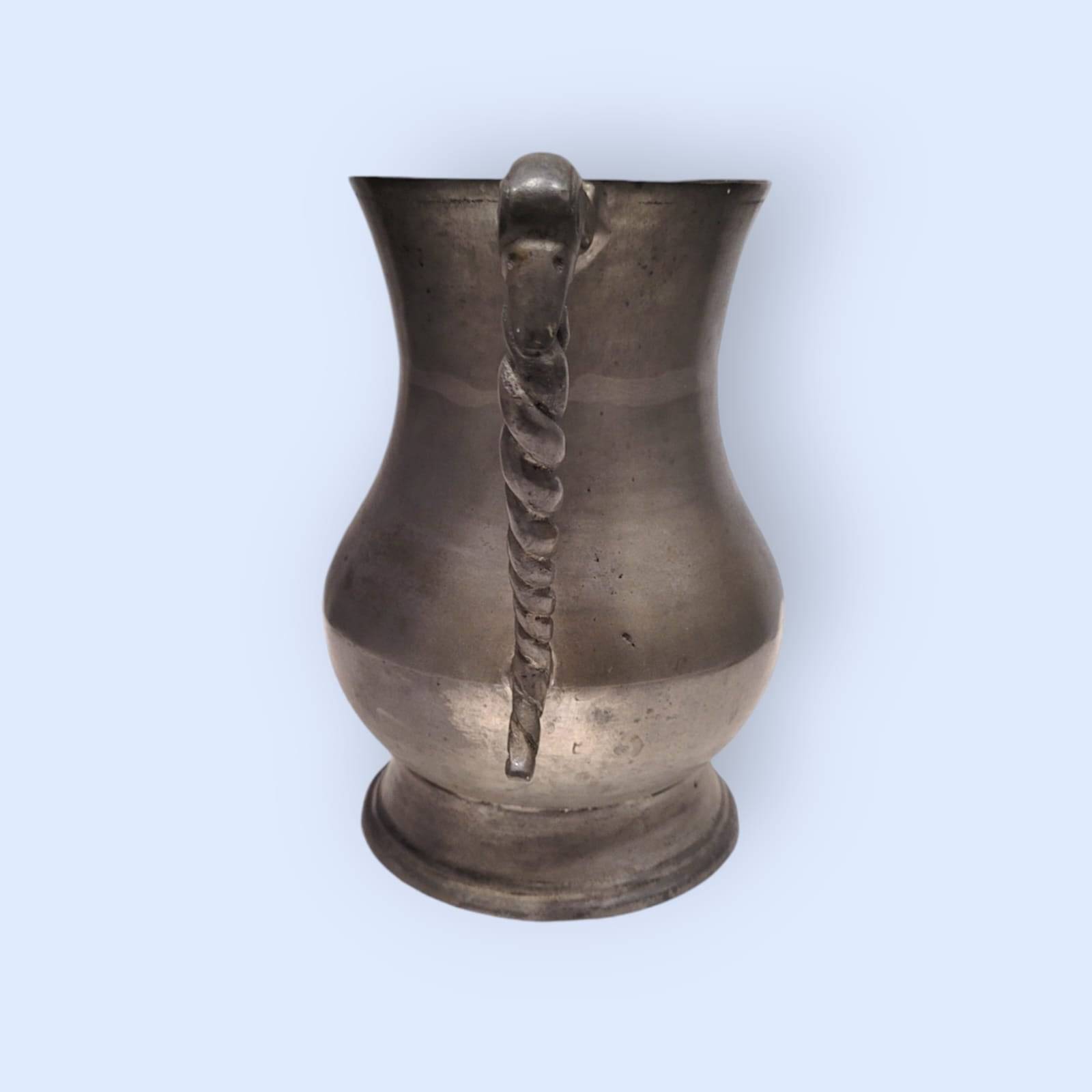 Vista trasera de jarra de peltre de estaño con asa trenzada, pieza decorativa de estilo clásico disponible en limbaproecher.com.