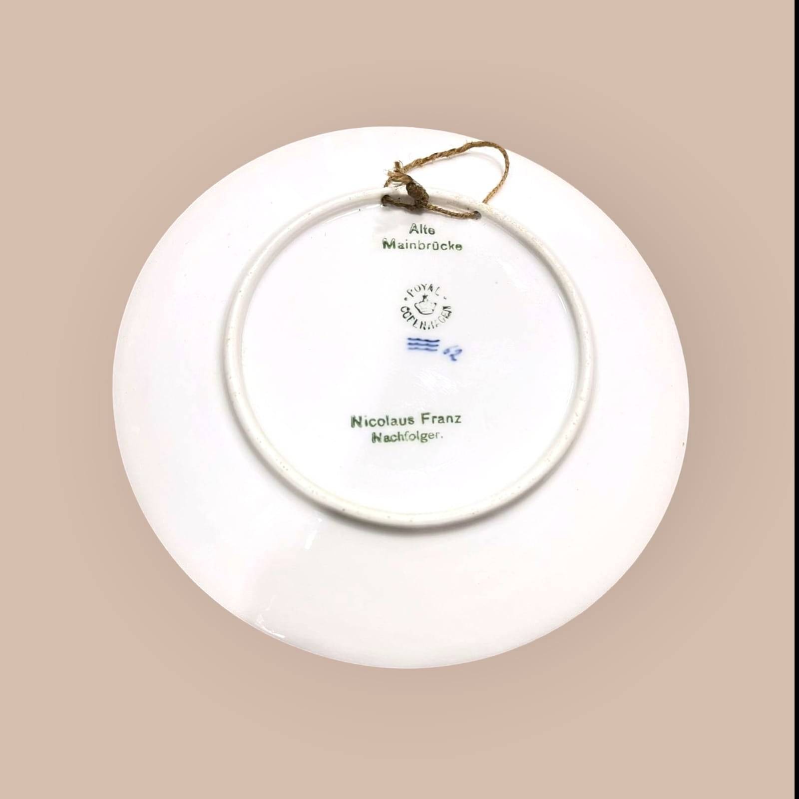 Reverso del Plato Decorativo Royal Copenhagen - Alte Mainbrücke con sello original, inscripción del fabricante y cuerda para colgar. Pieza de colección en porcelana danesa.
