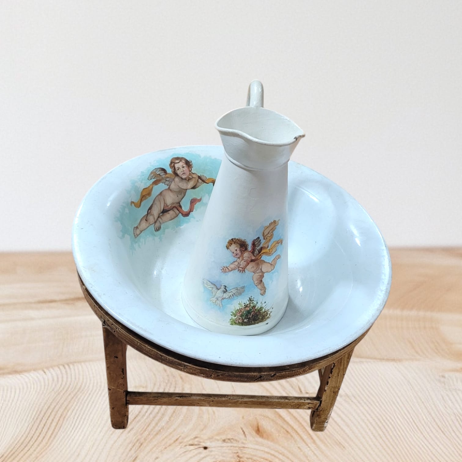 Elegante aguamanil Palaganero de la Cartuja con jarra blanca decorada con ángeles y base de madera, perfecto para decoración clásica.