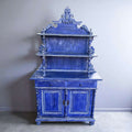 Aparador azul de madera con estantería y cajones en vista lateral.