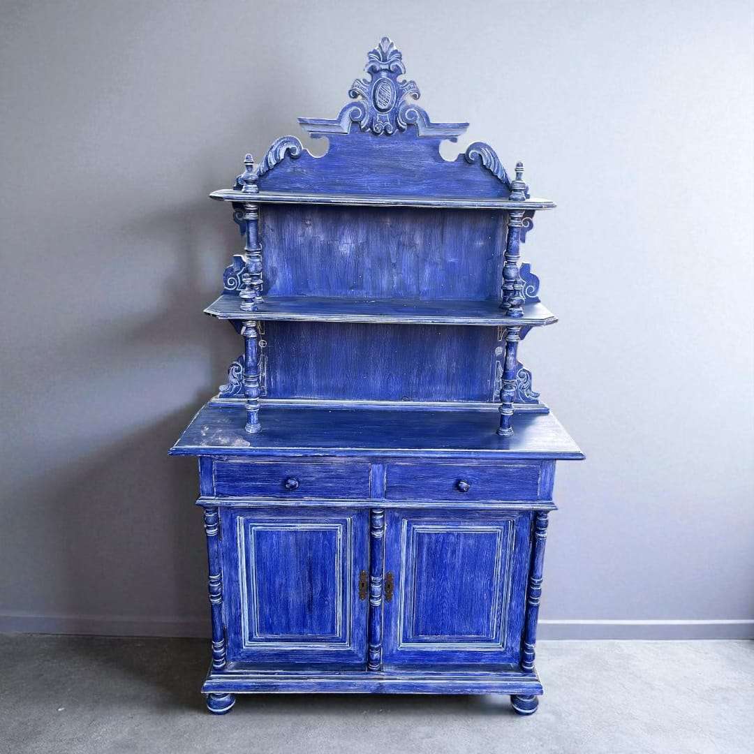 Aparador azul de madera con estantería y cajones en vista lateral.