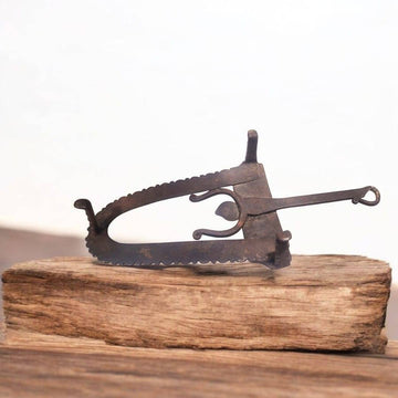 Descansa plancha hierro forjado antiguo con diseño curvo y detalles ornamentales, ideal para decoración vintage en hogar o colección.