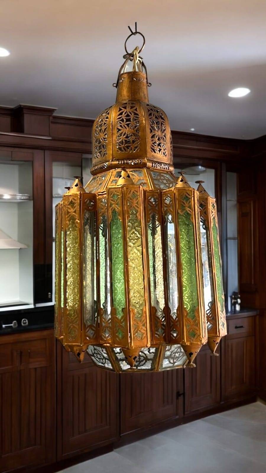 Farol decorativo árabe colgante con estructura de metal dorado y cristales verdes, ideal para dar un toque exótico a tu hogar o tetería.