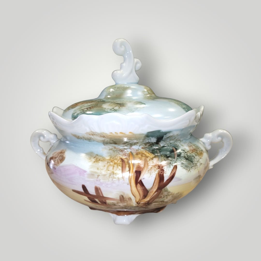 Bombonera de porcelana pintada a mano con paisajes naturales y tonos suaves. Diseño exclusivo para decoración de interiores.