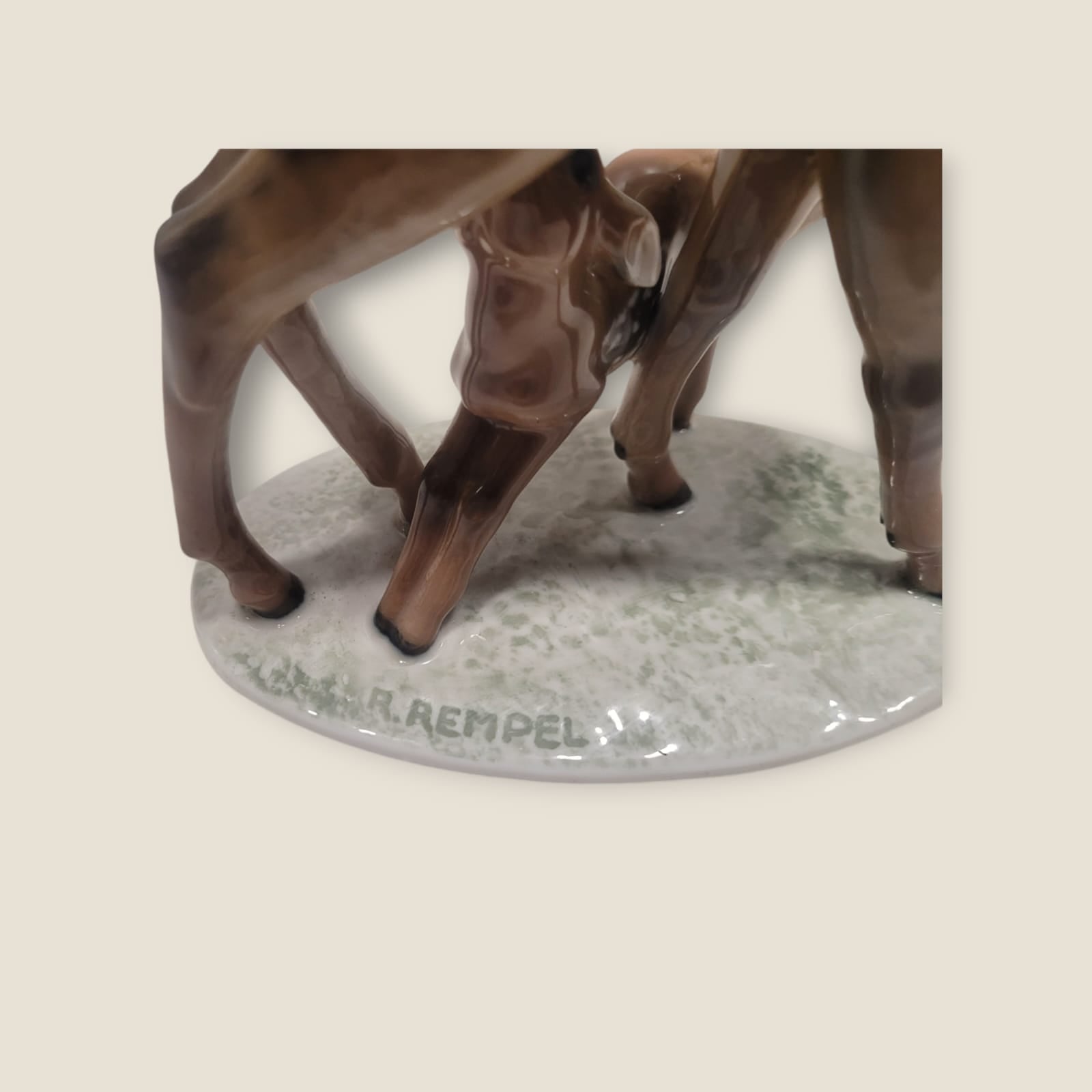 Detalle de la base de la figura de porcelana Rosenthal con la firma 'R. Rempel' grabada, resaltando su autenticidad.