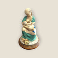 Escultura decorativa de madre amamantando con vestido verde y detalles florales, ideal para espacios de reflexión y maternidad.