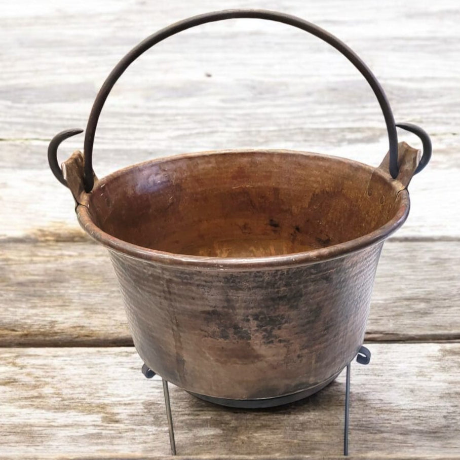 Caldero de cobre en ambiente rústico, utilizado como elemento decorativo en una cocina vintage .