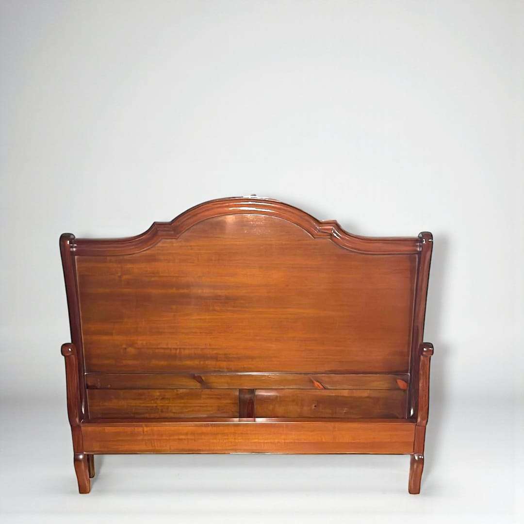 Vista lateral de cama de caoba con diseño robusto.