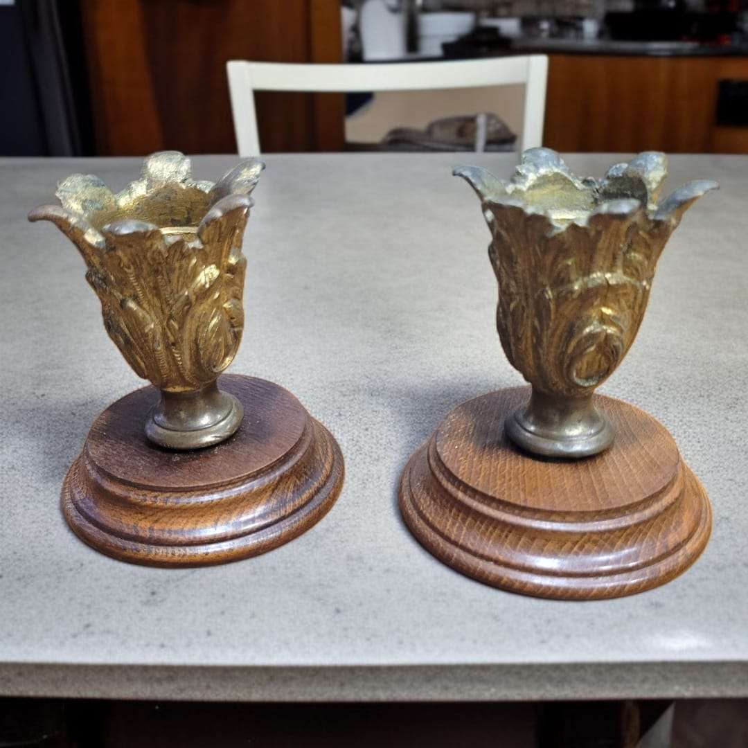 Candeleros colocados en simetría sobre mesa, con fondo neutro.
