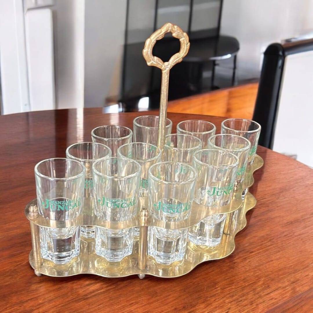 Set completo de cañero vintage dorado con 12 vasos de cristal Juncal, diseño elegante para decoración de interiores estilo retro.
