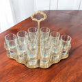 Cañero de metal dorado con diseño retro y 12 vasos de cristal Juncal, pieza decorativa única para hogar o colección temática.