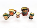 Colección de jarras decorativas Royal Doulton en porcelana esmaltada, con diseños detallados de personajes icónicos británicos.