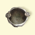 Vista superior del cenicero de bronce plateado ALMAZÁN con soportes decorativos y acabado envejecido, diseño floral artesanal.