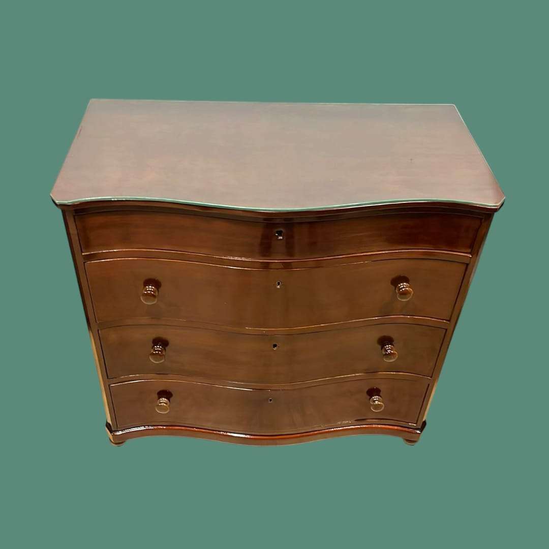 Cómoda de caoba con tapa de cristal y tres cajones con secreté, ideal para decoración elegante en interiores de hogar. Diseño clásico y funcional.