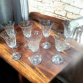 Juego de copas de cristal de Bohemia talladas con luz natural resaltando su diseño. Elegancia y tradición para tu mesa.