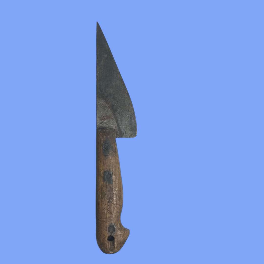 Perspectiva lateral del cuchillo de carnicero antiguo mostrando la hoja afilada.
