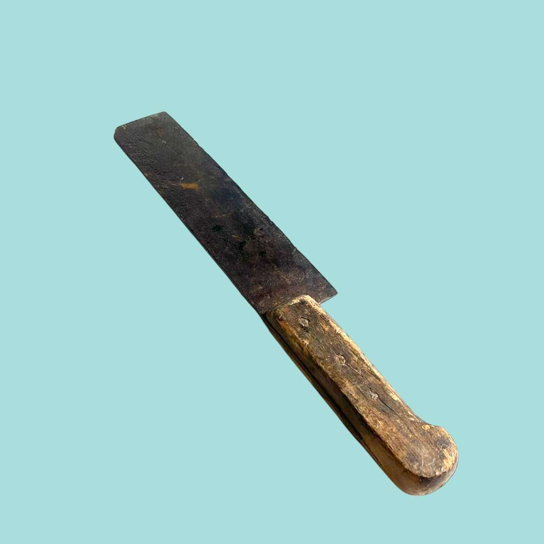 Cuchillo antiguo completo con mango de madera sobre fondo liso.