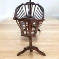 Cuna mecedora de madera oscura estilo Art Nouveau, fabricada entre 1890 y 1920, con diseño elegante y funcional.